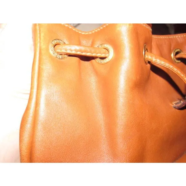 Gucci caramel brown colored leather, two strap, petite, drawstring top, multi-pocket, messenger bag/backpackk